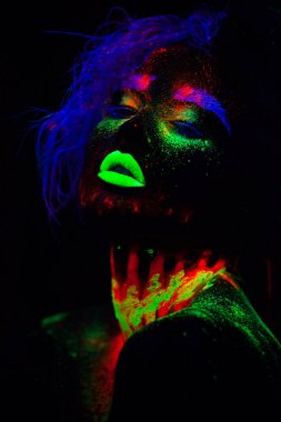 Beautiful extraterrestrial model woman with blue hair and green lips in neon light. It is portrait of beautiful model with fluorescent make-up, Art design of female posing in UV with colorful make up clipart