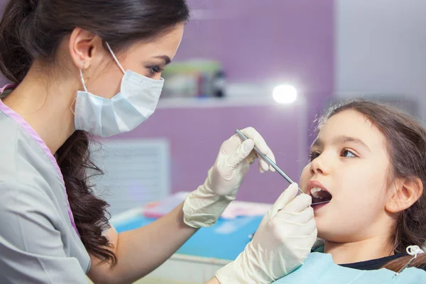 Primo piano della bella bambina che apre la bocca durante il trattamento dei denti dal dentista — Foto Stock