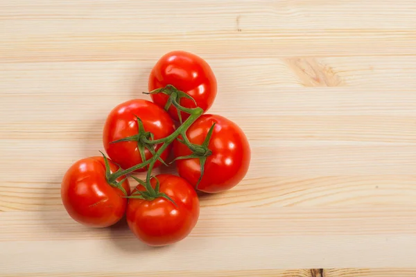 Tomates rojos frescos en la mesa de madera, aislados — Foto de Stock