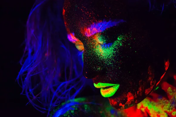 Schöne außerirdische Model-Frau mit blauem Kopf und grünen Lippen in Neonlicht. es ist Porträt des schönen Modells mit fluoreszierendem Make-up, Kunstdesign der weiblichen posiert in UV mit buntem Make-up — Stockfoto