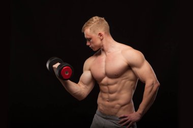 Atletik yakışıklı adam fitness-modeli halterle çalışma dışarı ve onun mükemmel vücut gösterilen. siyah arka plan ile boşaltmak izole