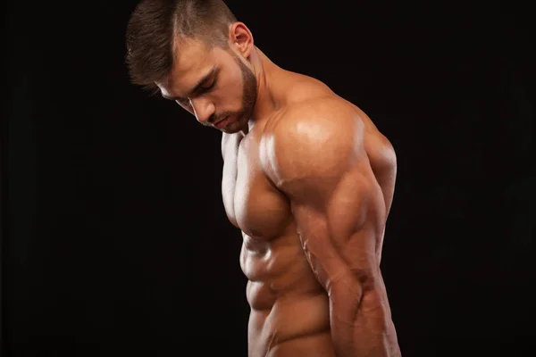 Erős sportos férfi - Fitness modell mutatja az elszigetelt fekete háttér copyspace tökéletes hátán — Stock Fotó
