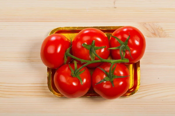 五个新鲜红番茄与绿色干在托盘中，孤立的背景 — 图库照片
