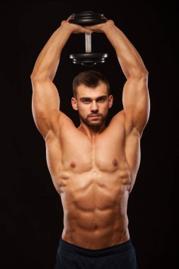Güçlü adam egzersizleri triceps bir dumbbell ile yapmak. Atış eğitim eller yukarı kapatın. Onun gövde altı ile gösterilen fitness modeli bohça abs. boşaltmak siyah zemin üzerine izole