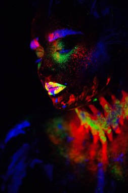 Güzel dünya dışı model neon ışık kadında. Bu güzel modeli ile floresan makyaj, kadın Uv renkli makyaj ile poz sanat tasarım portresi var. Siyah arka plan üzerine izole