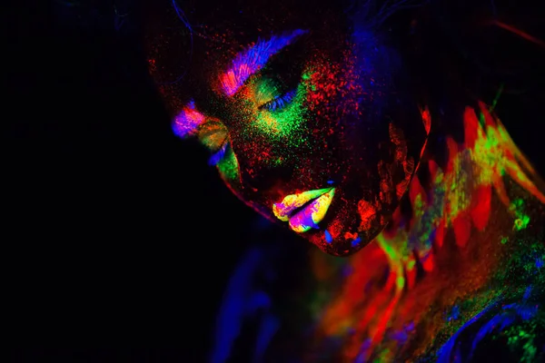 Hermosa mujer modelo extraterrestre en luz de neón. Es retrato del modelo hermoso con el maquillaje fluorescente, diseño del arte de la hembra que posa en ULTRAVIOLETA con el maquillaje colorido. Aislado sobre fondo negro — Foto de Stock