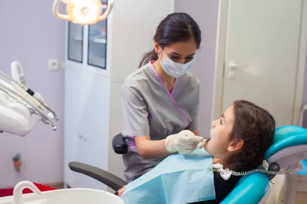 Całkiem mała dziewczynka otwierał usta szeroki podczas leczenia zębów przez dentystę — Zdjęcie stockowe