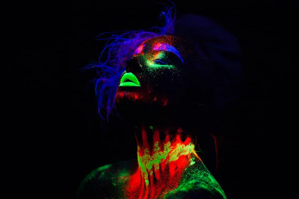 Hermosa mujer modelo extraterrestre con cabello azul y labios verdes en luz de neón. Es retrato del modelo hermoso con el maquillaje fluorescente, diseño del arte de posar femenino en ULTRAVIOLETA con el maquillaje colorido — Foto de Stock