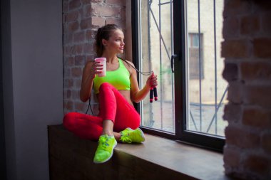 güzel genç kız bir fitness yüzlü içiyor. Sağlıklı yaşam konsepti.