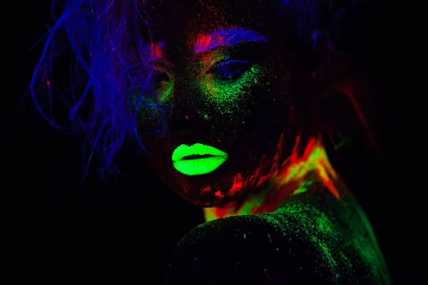 Bella donna modello extraterrestre con capelli blu e labbra verdi in luce al neon. È ritratto vicino di bel modello con trucco fluorescente, Progetto artistico di femmina che posa in UV con colorato — Foto Stock