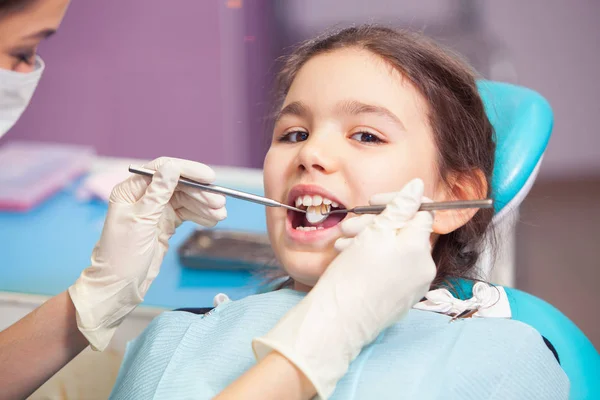 Primer plano de la hermosa niña abriendo la boca durante el tratamiento de sus dientes por el dentista —  Fotos de Stock