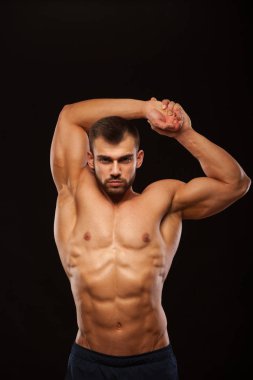 Güçlü atletik Man - Fitness modeli onun gövde altı bohça abs ile gösterilen ve ellerini dayanabiliyor. siyah arka plan ile boşaltmak izole