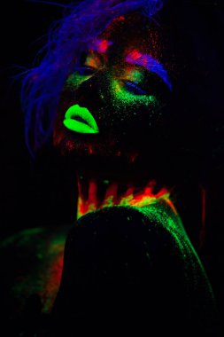 Güzel dünya dışı model kadın mavi saçlı ve neon ışık yeşil dudaklar. Floresan Makyajlı kadın Uv renkli makyaj ile poz sanat tasarım güzel model portresi olduğunu