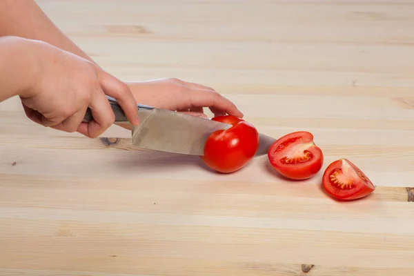 Cortar los tomates para los platos en la mesa. Hortalizas durante el proceso de cocción de los platos. Hortalizas para una alimentación y una dieta saludables — Foto de Stock