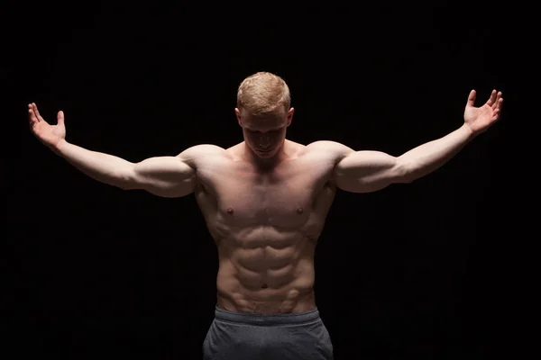 Modelo de fitness atlético bonito homem está mostrando seis pack abs. isolado em fundo preto com copyspace — Fotografia de Stock