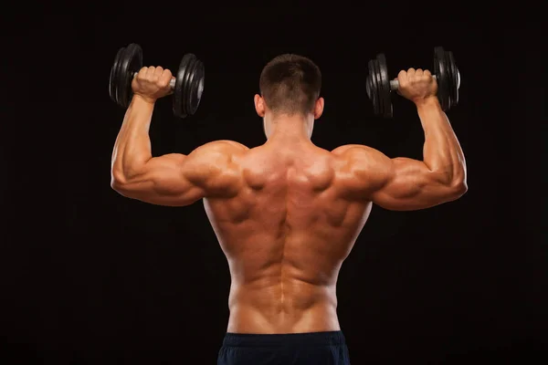 Muskulöser männlicher Model-Bodybuilder, der Übungen mit Kurzhanteln macht, umgedreht. isoliert auf schwarzem Hintergrund mit Copyspace — Stockfoto