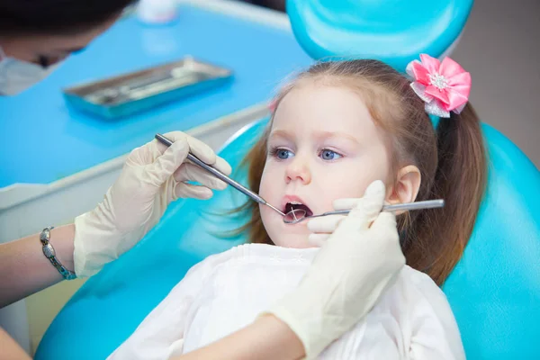 Primo piano della bella bambina che apre la bocca durante l'ispezione della cavità orale dal dentista — Foto Stock