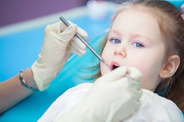 Primo piano della bella bambina che apre la bocca durante l'ispezione della cavità orale dal dentista — Foto Stock