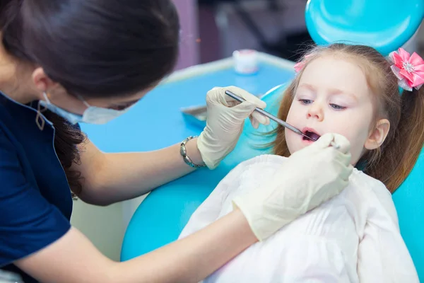 Primo piano della bella bambina che apre la bocca durante l'ispezione della cavità orale dal dentista — Foto Stock