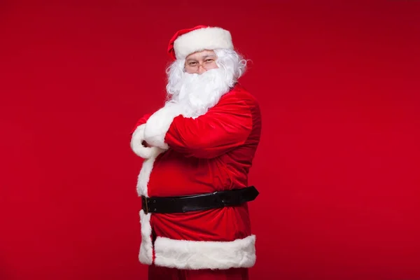 Weihnachtsmann tanzt vereinzelt auf rotem Hintergrund. — Stockfoto