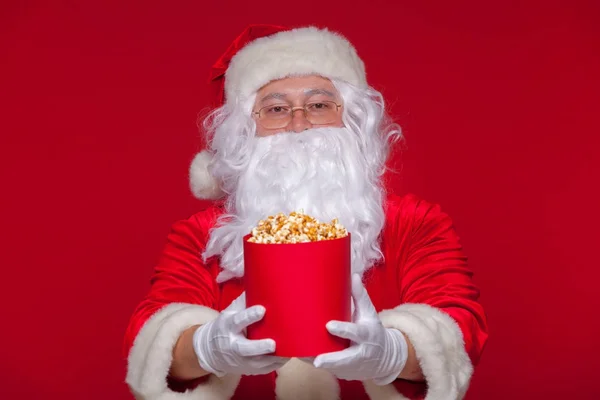 Père Noël traditionnel regardant la télé, mangeant du pop-corn. Noël. Fond rouge. émotions peur surprise — Photo
