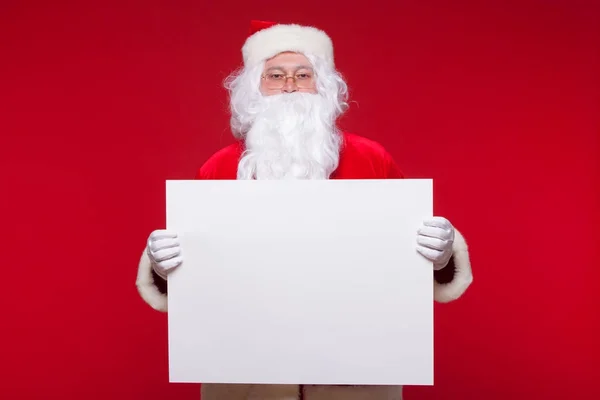 Santa Claus pointing in blank advertisement banner isolated on red background with copy space — Stock Photo, Image