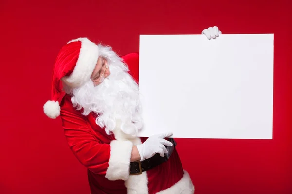 Santa Claus pointing in blank advertisement banner isolated on red background with copy space — Stock Photo, Image