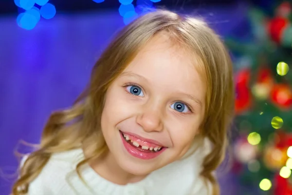 Un gran retrato de un niño sobre un fondo de luces navideñas — Foto de Stock