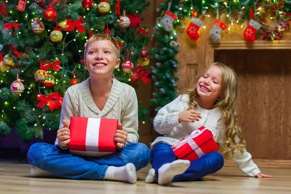 Familia en la víspera de Navidad en la chimenea. Niños abriendo regalos de Navidad — Foto de Stock