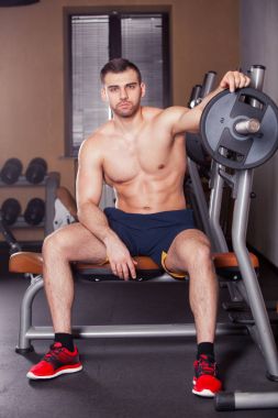 Zalim atletik adam göğüs presinde kaslarını şişiriyor.