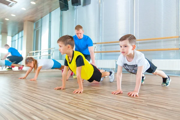 Los niños en la lección de educación física en la escuela gimnasta niño —  Fotos de Stock