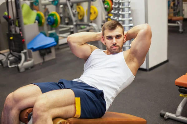 Deporte, fitness, musculación, estilo de vida y el concepto de las personas - joven haciendo ejercicios abdominales sit-up Banco de prensa en el gimnasio —  Fotos de Stock