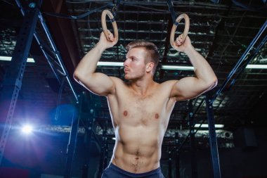 Kaslı adam Yüzüklerin uygun stili çapraz üzerinde egzersiz yaparak