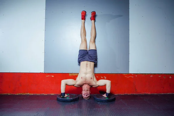 年轻男子运动员做极端俯卧撑倒立作为健美训练的一部分 — 图库照片