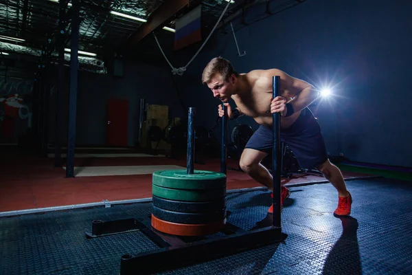 sled push man pushing weights workout exercise at gym. Cross fit style