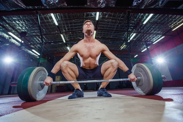 Muscular fitness man preparing to deadlift a barbell over his head in modern fitness center.Functional training.Snatch exercise. — Stock Photo, Image