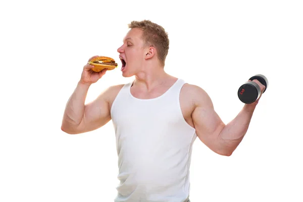 胖子拿着汉堡包, 把哑铃放在白色。在有害食物和健康生活方式之间选择的概念。超重的人谁坏了健康膳食的肖像。垃圾餐 — 图库照片