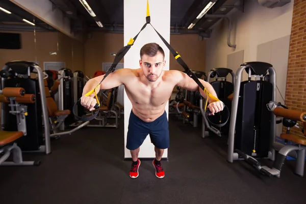 Attraktiv Man gör Crossfit Push Ups med Trx Fitness remmar i gym Studio — Stockfoto