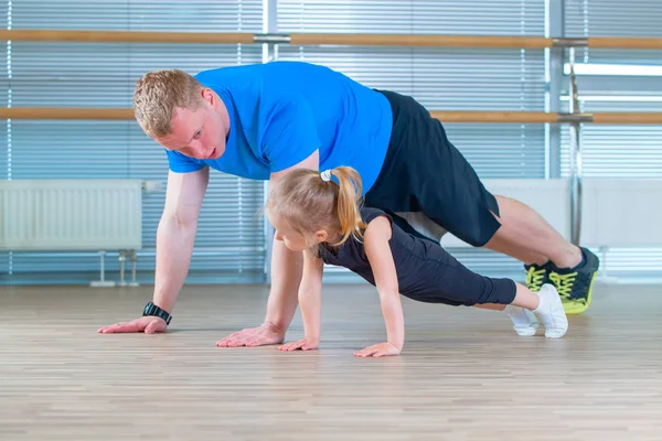 Grupp barn gör barn gymnastik i gymmet med lärare. Glada sportiga barn i gymmet. bar utöva. plankan. — Stockfoto