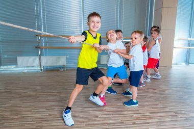 Çocuk ve Rekreasyon, grup mutlu çok ırklı okulun spor salonunda halat çekme halatı ile oynayan çocuklar