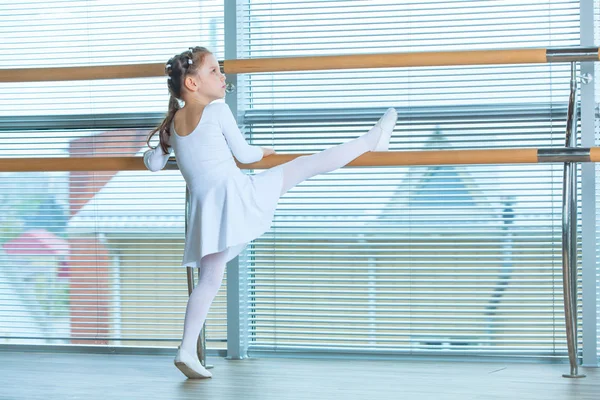 Uma bailarina com um tutu cor-de-rosa. Criança adorável dançando balé clássico em um estúdio branco. As crianças dançam. Crianças a actuar. Jovem dançarina talentosa numa aula. Criança pré-escolar tendo aulas de arte . — Fotografia de Stock