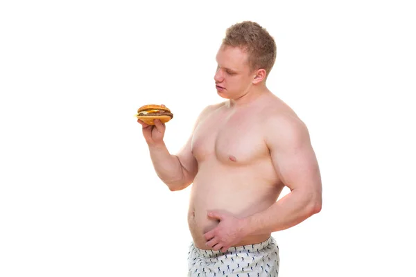 Gros homme avec hamburger isolé repas de malbouffe conduit à l'obésité. Perturbation du concept de régime alimentaire. Il essaie de suivre un régime . — Photo