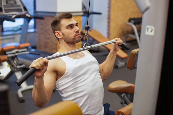 Homem com treinamento de peso em equipamento de ginásio clube desportivo — Fotografia de Stock