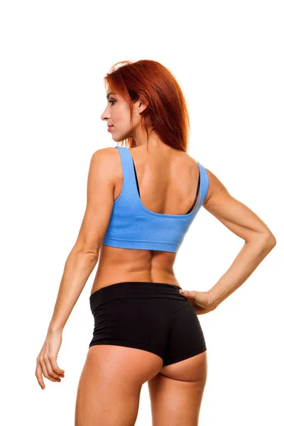 Beyaz arka plan üzerinde ayakta kas genç kadın atlet. Kadın vücut geliştirmeci egzersiz sonrası dinlendirici. — Stok fotoğraf