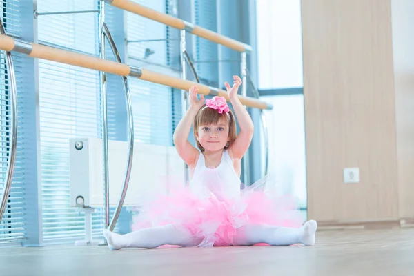 Uma bailarina com um tutu cor-de-rosa. Criança adorável dançando balé clássico em um estúdio branco. As crianças dançam. Crianças a actuar. Jovem dançarina talentosa numa aula. Criança pré-escolar tendo aulas de arte . — Fotografia de Stock