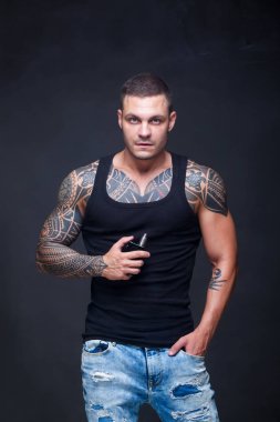 Vaper. Dövmeli kas bir gövde adamla koyu arka plan üzerinde elektronik sigara duman