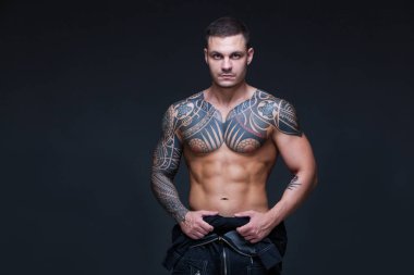 Bir kaslı çıplak gövde koyu arka plan üzerine dövmeli olan adam. ABS