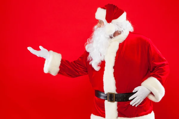 Weihnachtsmann zeigt auf einen leeren Platz, roter Hintergrund — Stockfoto