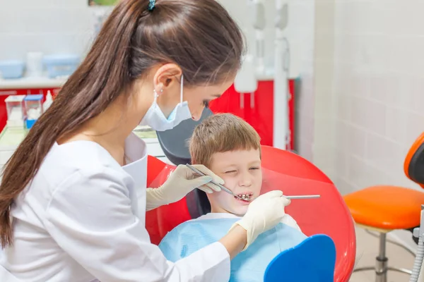 Un bambino con un dentista in uno studio dentistico . — Foto Stock