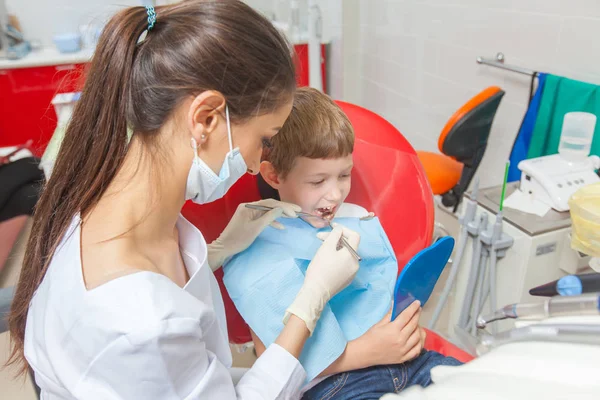 Un bambino con un dentista in uno studio dentistico . — Foto Stock